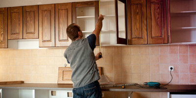 man installing cabinets in kitchen